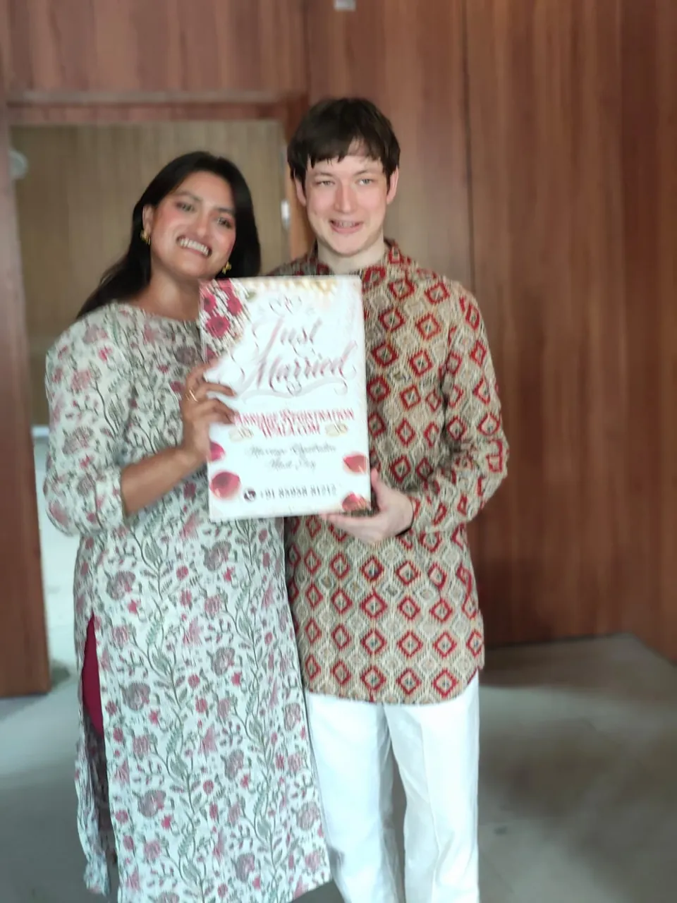 Both partners, US citizens, holding a Just Married placard after marrying and registering in India